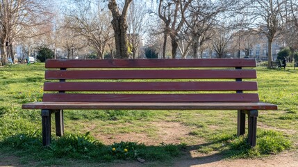 Wooden park bench in a sunlit grassy area surrounded by trees, inviting relaxation and peaceful outdoor moments in a serene setting
