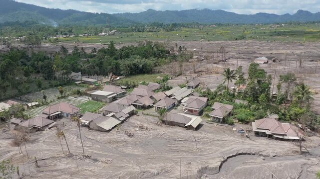 Aerial footage showing a village and landscape buried in volcanic mudflow and ash after the eruption of mount semeru in east java, indonesia