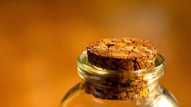 Close-up of a natural cork stopper sealing a clear glass bottle