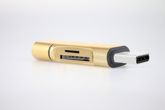 Gold USB-C OTG flash drive adapter with SD and microSD memory card reader isolated on white background. Portable storage device for smartphone, tablet and laptop data transfer, digital backup and save
