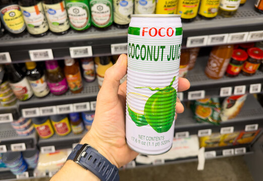 FOCO Coconut Juice Can Held by Shopper in Grocery Store Aisle