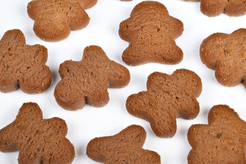 Spiced treats on bright surface. Decorative cookies with coarse sugar on white background. Festive gingerbread shapes with warm tones and crisp edges displayed neatly