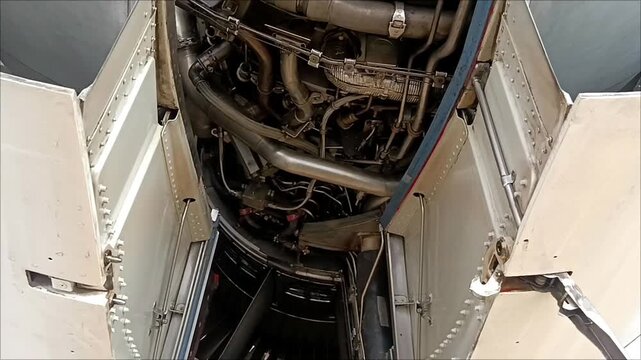 Jet engine thrust reverser opened during maintenance, revealing internal aircraft engine components
