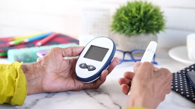 Close up hands holding blood glucose meter and lancing device checking blood sugar level with copy space on white background