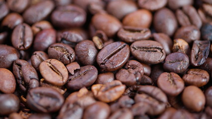 Naklejka premium Coffee beans closeup, Roasted beans with rustic charm, Detailed view of aromatic roasted coffee beans, Closeup of glossy roasted coffee beans with textured surface
