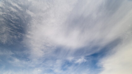 Fototapeta premium Expansive sky filled with gentle clouds and sunlight shine through, Broad sky featuring delicate cloud formations illuminated by soft sunlight and clear atmosphere