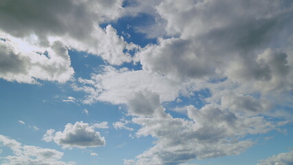 Dynamic clouds drift across a blue sky during the day, creating a picturesque view © beholdereye