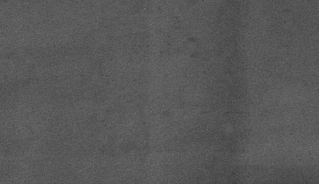 Close-up textured grey paper background with subtle grain and slight shadow.
