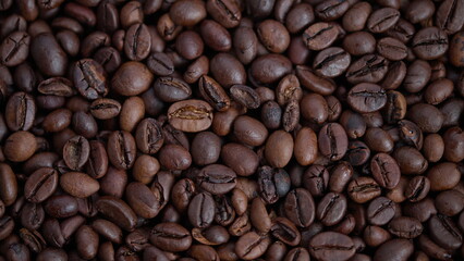 Obraz premium Rich roasted beans with shine, Texture detailed roasted coffee beans with shiny highlights, Closeup of roasted coffee beans showing glossy surface and textured cracks