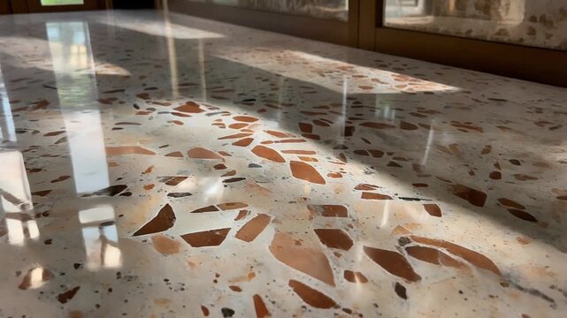 A polished terrazzo floor reflecting sunbeams in a modern interior space with natural light pouring through the windows