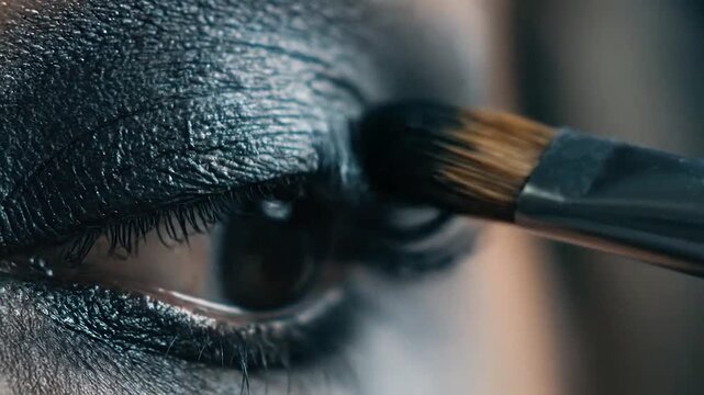 Close-up of eye makeup application with a brush