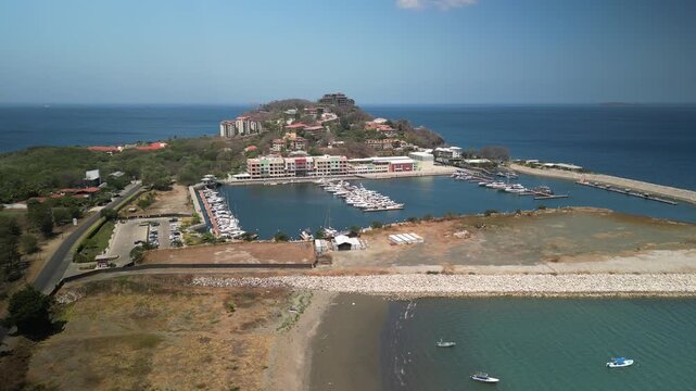 Aerial of Playa Flamingo marina in Costa Rica with boats on blue sky day