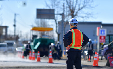 街路舗装工事を監督する工事部長