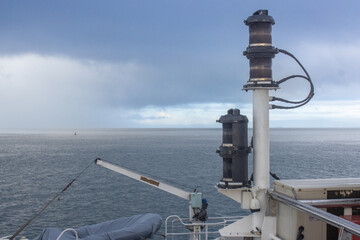 Marine Navigation Lanterns and Lifeboat on Ship Deck Under Stormy Sky