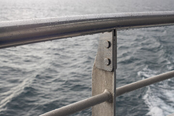 Safety Railing and Metal Guard on Ship Deck Above the Deep Blue Sea
