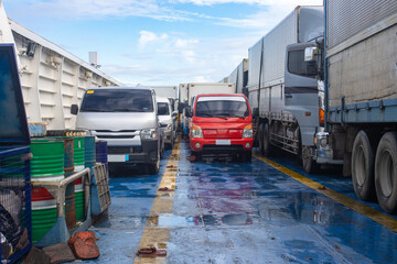Commercial Vehicles and Trucks Parked on a Ferry Cargo Deck During Sea Transit