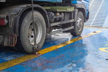 Cargo Securing Ratchet Strap Fixing a Heavy Truck to a Ferry Ship Deck