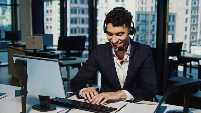male agent unspecified headset office answering client inquiries, smiling while typing on keyboard, skyline view behind, multitasking with phone and CRM, professional customer service tone and helpful