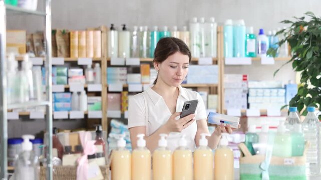 Young woman buyer scanning qr code for box of ointment in pharmacy