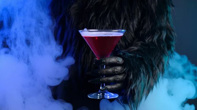 Furry Creature Hand Holding Red Cocktail Amidst Blue Smoke