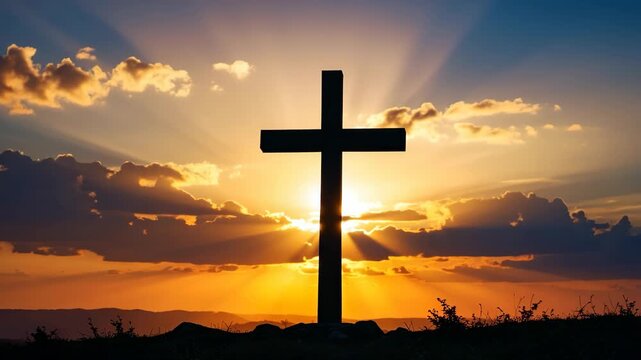 Silhouette of a Christian cross against a dramatic sunset with radiant sunbeams and clouds