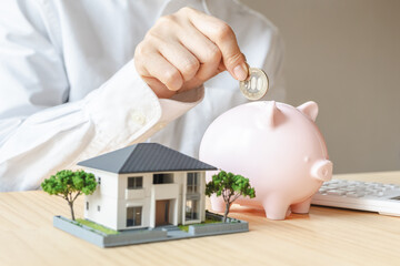 家の模型と貯金箱　住宅購入や住宅ローンのイメージ素材