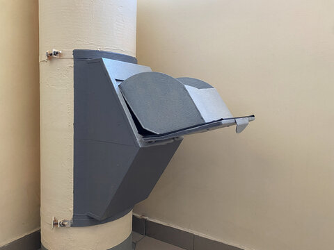 Open door or hatch of garbage chute in multi-storey building. Large diameter pipe in apartment building runs through all floors. Convenient garbage and waste collection system