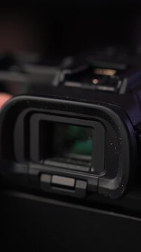 Slow rotating close-up of mirrorless camera electronic viewfinder and eyecup, highlighting optical details in studio light. Vertical b-roll.