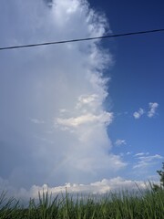 Fototapeta premium Dynamic weather spectacle where a vast, dark storm cloud front dramatically converges with a clear, vibrant blue sky, revealing nature's powerful atmospheric transition