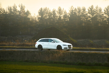 Fototapeta premium White car driving through countryside