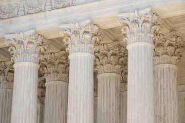 Naklejka premium Marble pillars highlight classical architecture. Monumental columns dominate historic architecture. White stone columns express civic design. Tall marble columns define grand architecture.