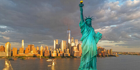 Fototapeta premium Statue of Liberty in New York City. Liberty statue near New York City harbor, America. New York City cityscape. Statue of Liberty in NYC, USA. New York City skyline.