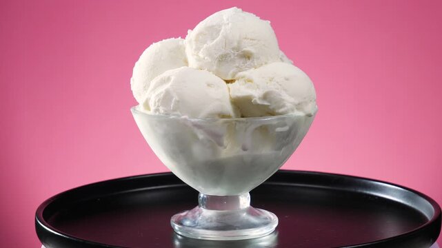 Vanilla ice cream in a glass slowly rotates around its axis