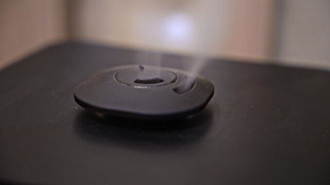 Closeup view of air humidifier operating and producing cool mist. Household device increasing humidity level inside room environment.