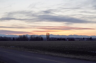 Obraz premium Rural sunset scene in Idaho over farmland, clouds in the sky and beautiful color.