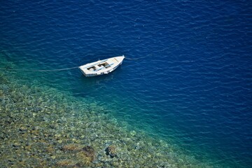 Fototapeta premium Seascape with scenic view of a traditional Greek fishing boat on the waters of Therasia island in Cyclades, South Aegean Greece.