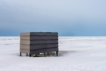 Beach Changing Cabin Surrounded by Snow on Baltic Sea Coast in Winter © Zigmunds