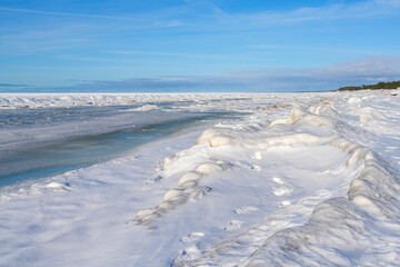 Snow and Ice Covered Baltic Sea Coastline Under Clear Blue Winter Sky © Zigmunds