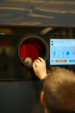 Child placing aluminum can into automated recycling machine. Return system, sustainability, eco responsibility and environmental education concept