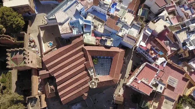 Stunning HD top-down aerial of Chefchaouen's medina, showcasing traditional inner courtyards with mosaic tiles and blue fountains. Captures the unique architecture of Morocco's Blue Pearl.