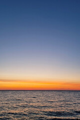 Fototapeta premium Serene Sunset Over Tranquil Ocean Horizon in Golden Hour