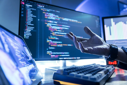 Programmers are working at their desks, writing and debugging computer code to ensure the system is running efficiently.