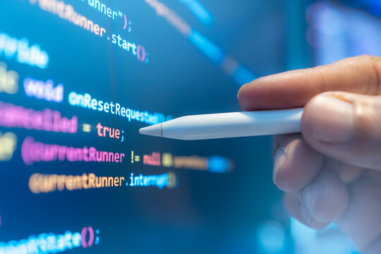 Software developers are examining computer code, which represents the concept of advanced technological information for building network security platforms.