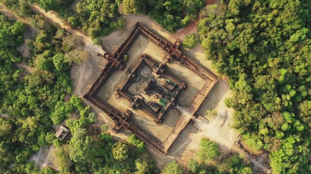Drone shot of the ancient Banteay Samre temple complex surrounded by lush green forest in Cambodia. The symmetrical architecture and natural landscape create a striking contrast.