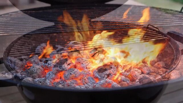 Close-up of glowing charcoal embers and flames heating up in a barbecue grill, ready for cooking