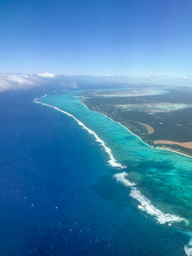 Looking down on turquoise blue ocean of Caribbean from airplane.