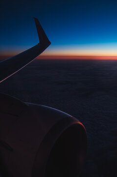 View of airplane wing and sky at sunset from the air.