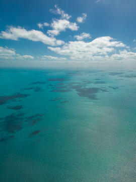 Looking down on turquoise blue ocean of Caribbean from airplane.
