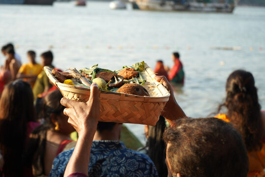 Indian devotees carrying traditional offerings in a wicker basket during Chhath Puja festival at the Ganges river