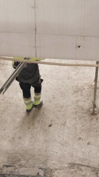 Worker carrying pipe at constriction site